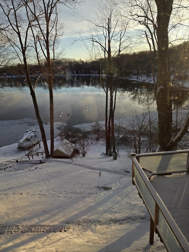 yard covered in snow featuring a water view