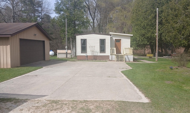 view of front of house with a garage, a front lawn, and an outbuilding