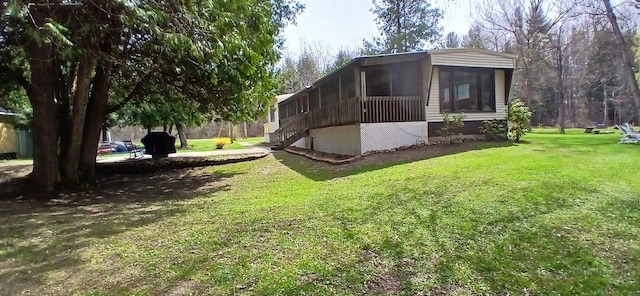 view of side of property featuring a yard, stairs, and a sunroom