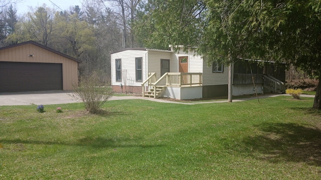 manufactured / mobile home with an outbuilding, a front yard, and a detached garage