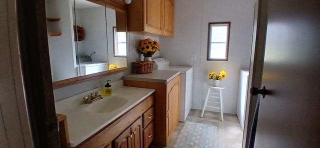 bathroom featuring vanity and independent washer and dryer