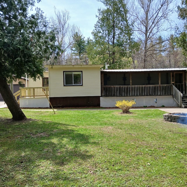 view of front of house featuring a deck, a front yard, and a sunroom