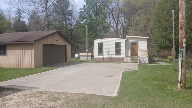 view of front facade featuring a detached garage, an outbuilding, and a front yard