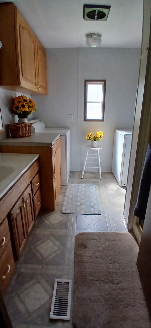 laundry area with cabinet space and visible vents
