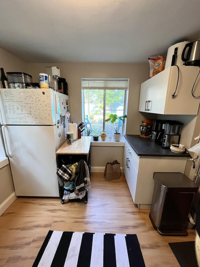 1514 Golden Ave, Ann Arbor, MI 48104 - kitchen featuring dark countertops, baseboards, freestanding refrigerator, and light wood-type flooring