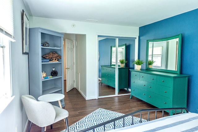 bedroom with a closet, wood finished floors, and baseboards