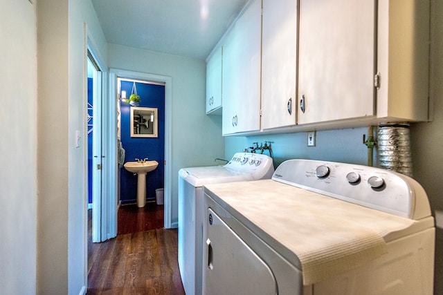 washroom featuring independent washer and dryer, cabinet space, and dark wood-style flooring