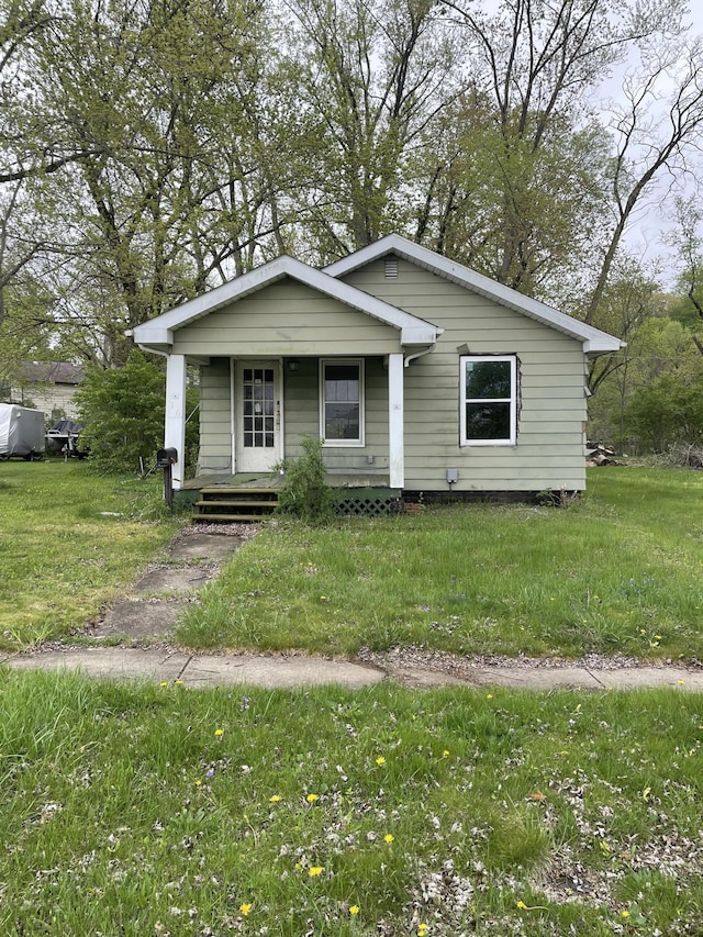 bungalow with a front lawn and covered porch