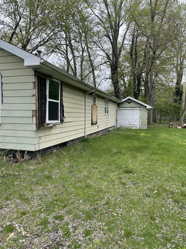 view of side of property with a lawn, an outbuilding, and a garage