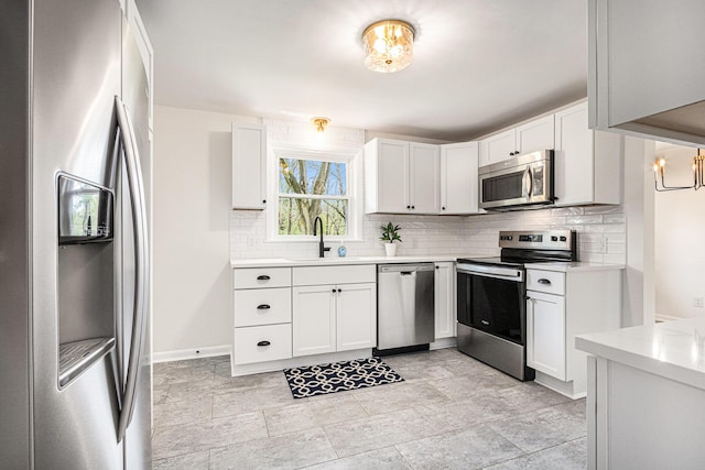 kitchen featuring backsplash, appliances with stainless steel finishes, a sink, and light countertops