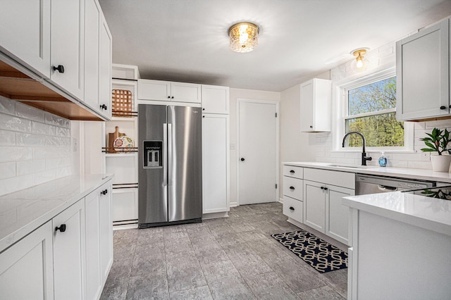 kitchen featuring a sink, white cabinetry, appliances with stainless steel finishes, and backsplash