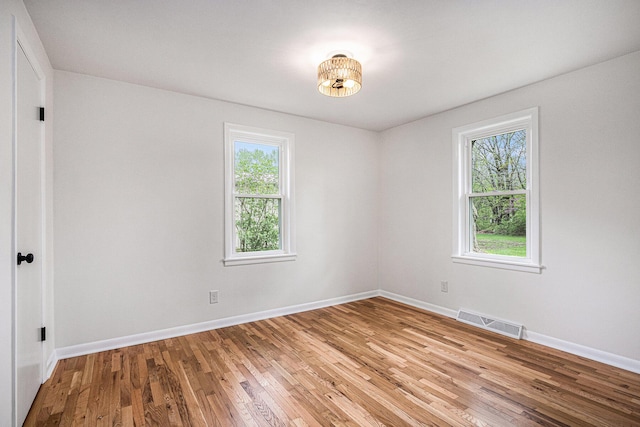 unfurnished room with baseboards, visible vents, and light wood-style flooring