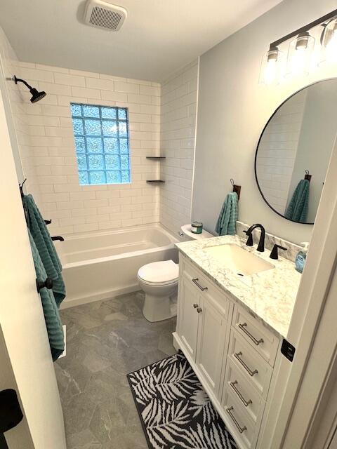 full bath featuring shower / washtub combination, vanity, toilet, and visible vents