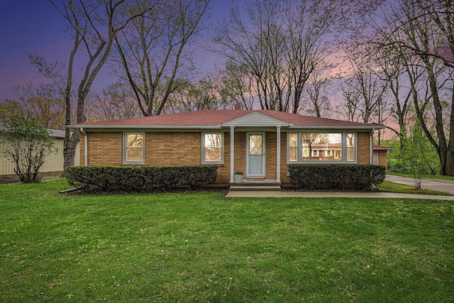 ranch-style home with brick siding and a front yard