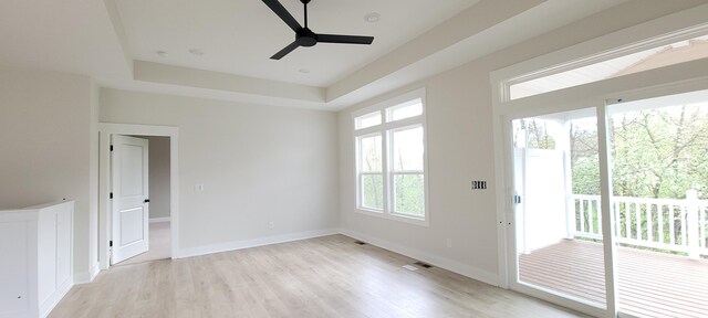 spare room with ceiling fan, light wood finished floors, visible vents, and a wealth of natural light