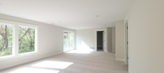unfurnished room featuring baseboards, visible vents, and light colored carpet