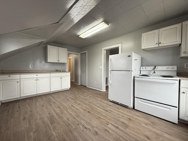 kitchen with vaulted ceiling, light countertops, white cabinets, light wood-style floors, and white appliances