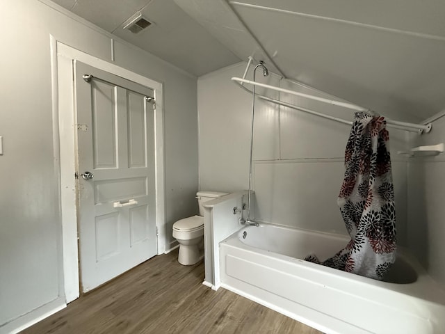 bathroom featuring toilet, shower / bathtub combination with curtain, wood finished floors, vaulted ceiling, and visible vents
