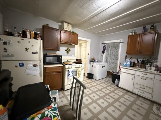 kitchen featuring light countertops, light floors, brown cabinets, and white appliances