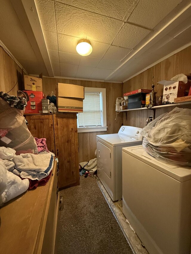 laundry area with carpet flooring, laundry area, wood walls, and washing machine and dryer