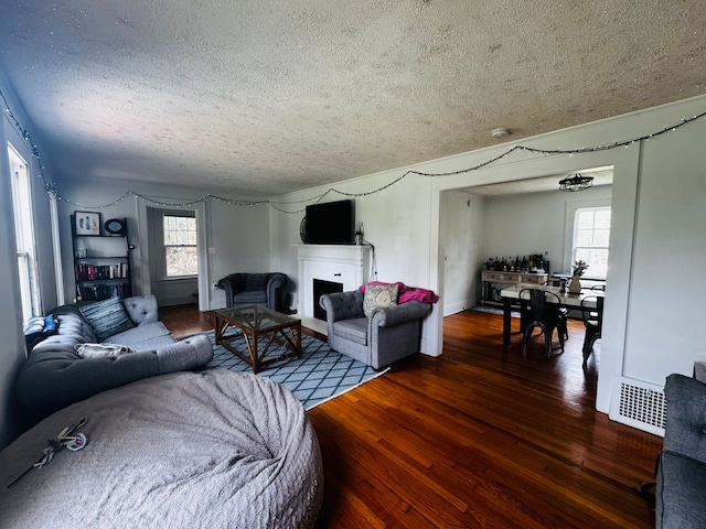 living area featuring a healthy amount of sunlight, visible vents, and a textured ceiling