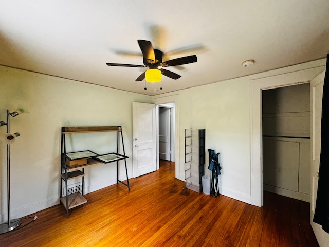 unfurnished bedroom with baseboards, a closet, a ceiling fan, and wood finished floors