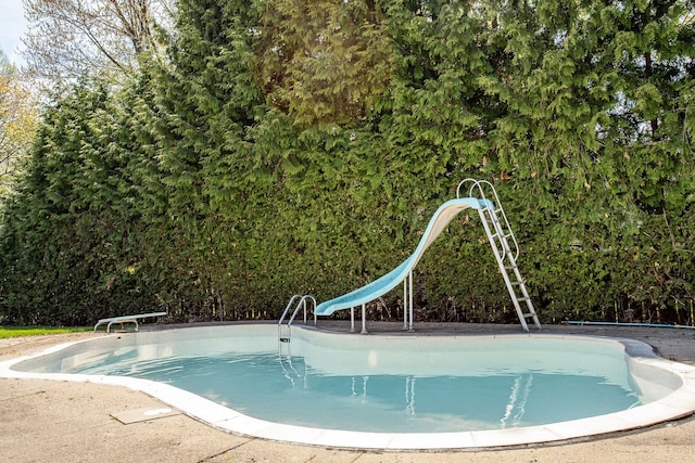 pool featuring a diving board and a water slide