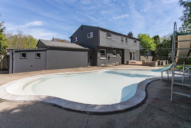 view of pool with a patio, an empty pool, a water slide, and fence
