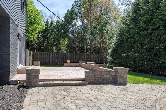 view of patio with fence and a deck