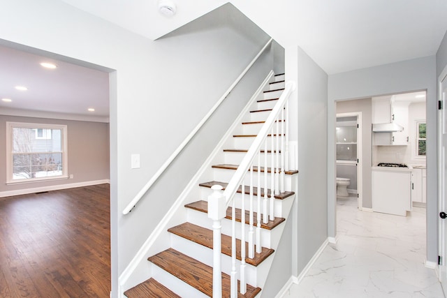 stairway featuring baseboards, plenty of natural light, recessed lighting, and marble finish floor