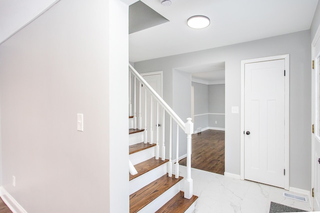 staircase featuring baseboards and marble finish floor