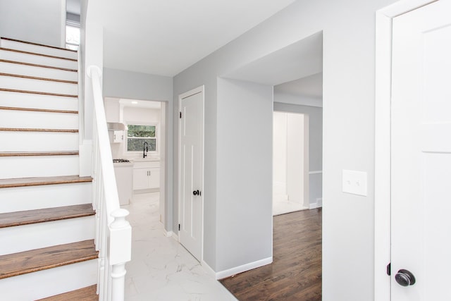 stairway featuring baseboards and marble finish floor