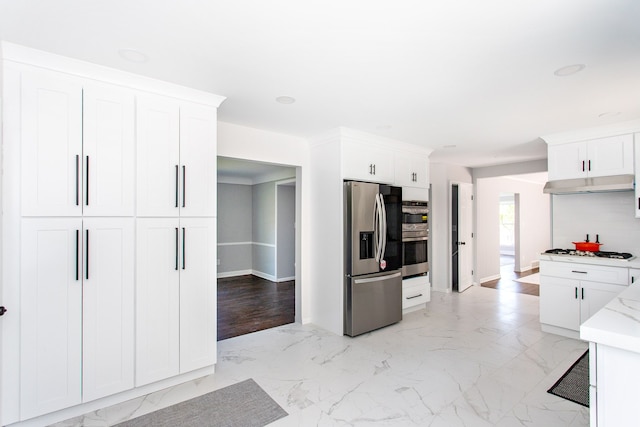 kitchen featuring white cabinets, stainless steel appliances, and marble finish floor