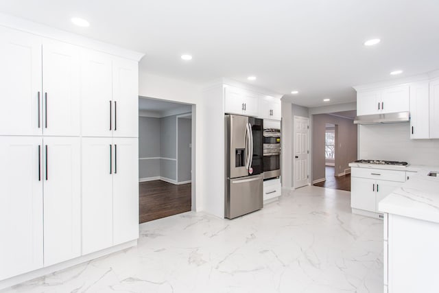 kitchen featuring marble finish floor, recessed lighting, white cabinetry, light stone counters, and appliances with stainless steel finishes