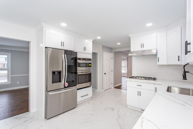 kitchen featuring recessed lighting, a sink, light stone countertops, and stainless steel appliances