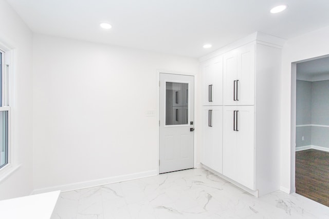 empty room with recessed lighting, baseboards, and marble finish floor