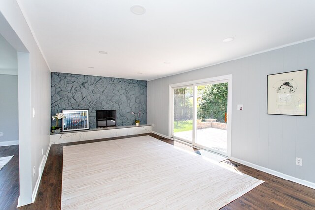 unfurnished living room featuring baseboards, a fireplace, wood finished floors, and visible vents
