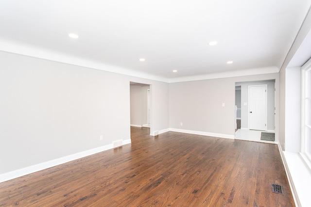 unfurnished room featuring dark wood-style flooring, recessed lighting, baseboards, and visible vents