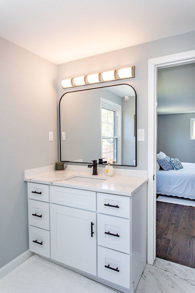 bathroom with vanity, connected bathroom, marble finish floor, and plenty of natural light