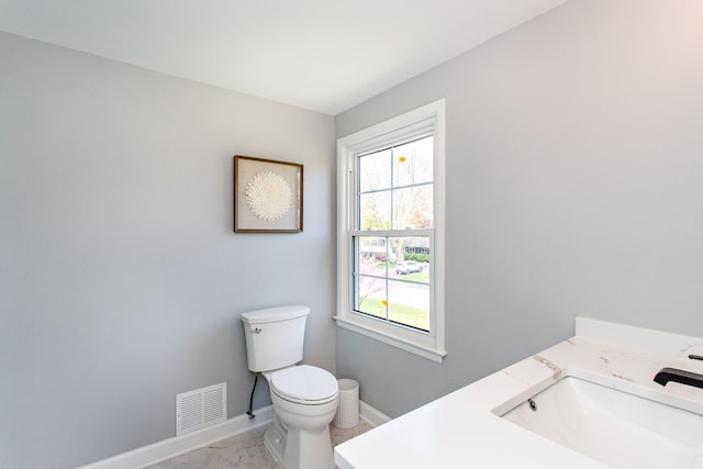 bathroom with vanity, toilet, marble finish floor, baseboards, and visible vents