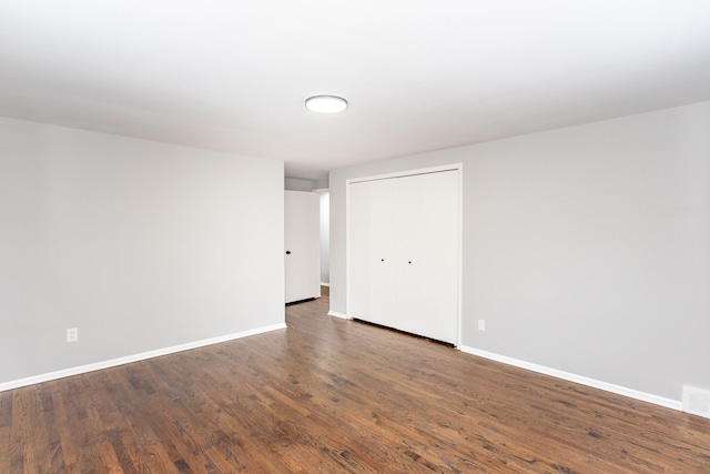 spare room featuring baseboards and wood finished floors