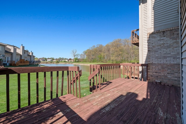 wooden deck with a water view and a yard