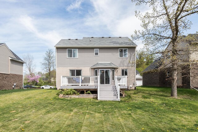 back of house featuring a lawn, brick siding, and a deck