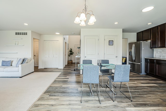dining area featuring a chandelier, recessed lighting, wood finished floors, and visible vents
