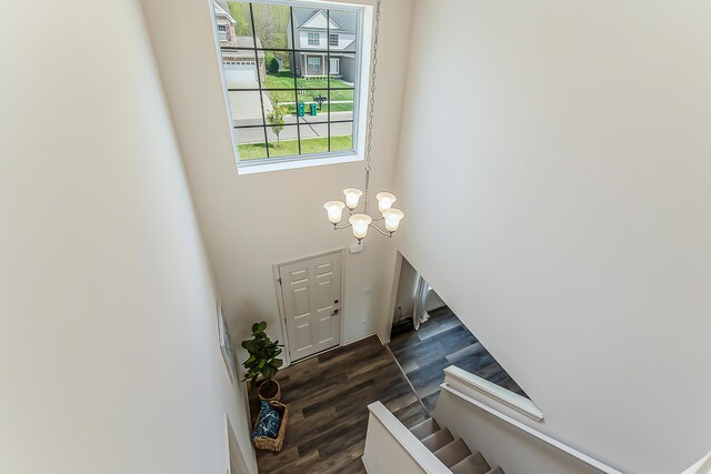 entryway with a notable chandelier, stairs, and dark wood-type flooring