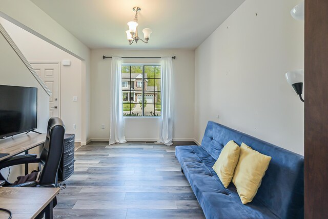 office featuring baseboards, wood finished floors, and a notable chandelier