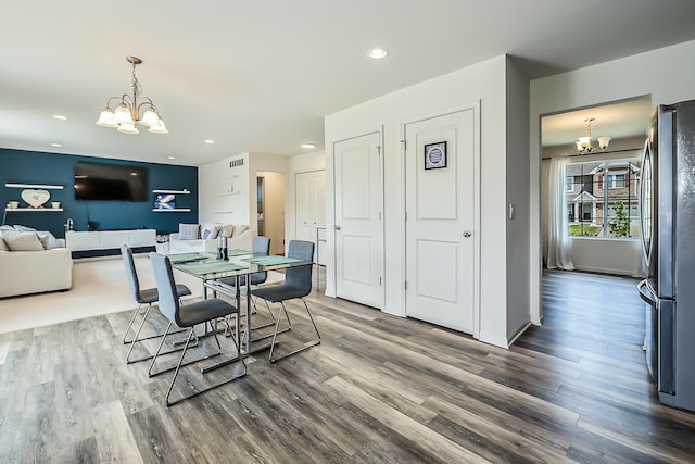 dining room with an inviting chandelier, recessed lighting, wood finished floors, and visible vents