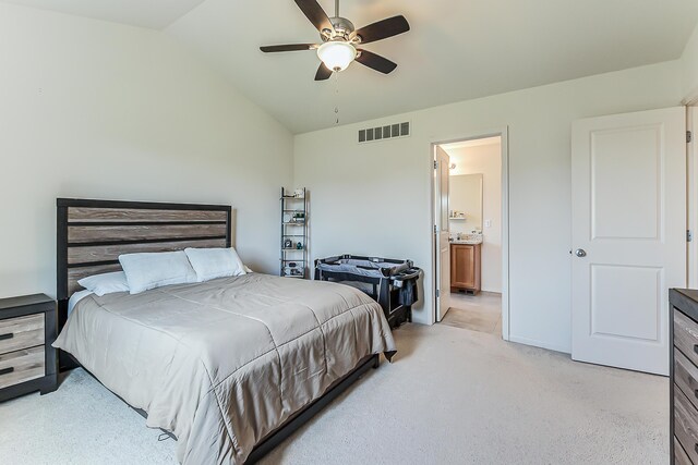 bedroom with visible vents, ensuite bathroom, ceiling fan, light colored carpet, and vaulted ceiling