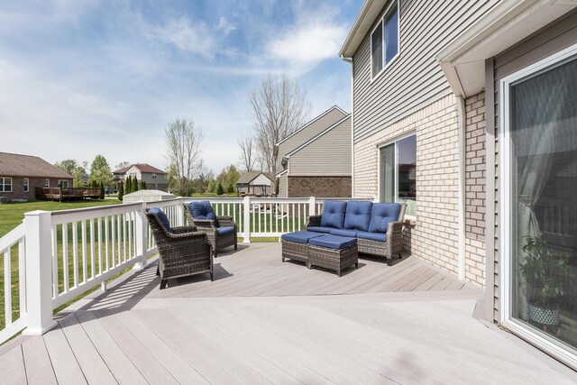 wooden deck with an outdoor hangout area and a yard