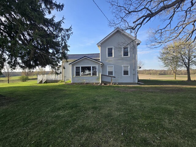 back of property featuring a lawn and a wooden deck